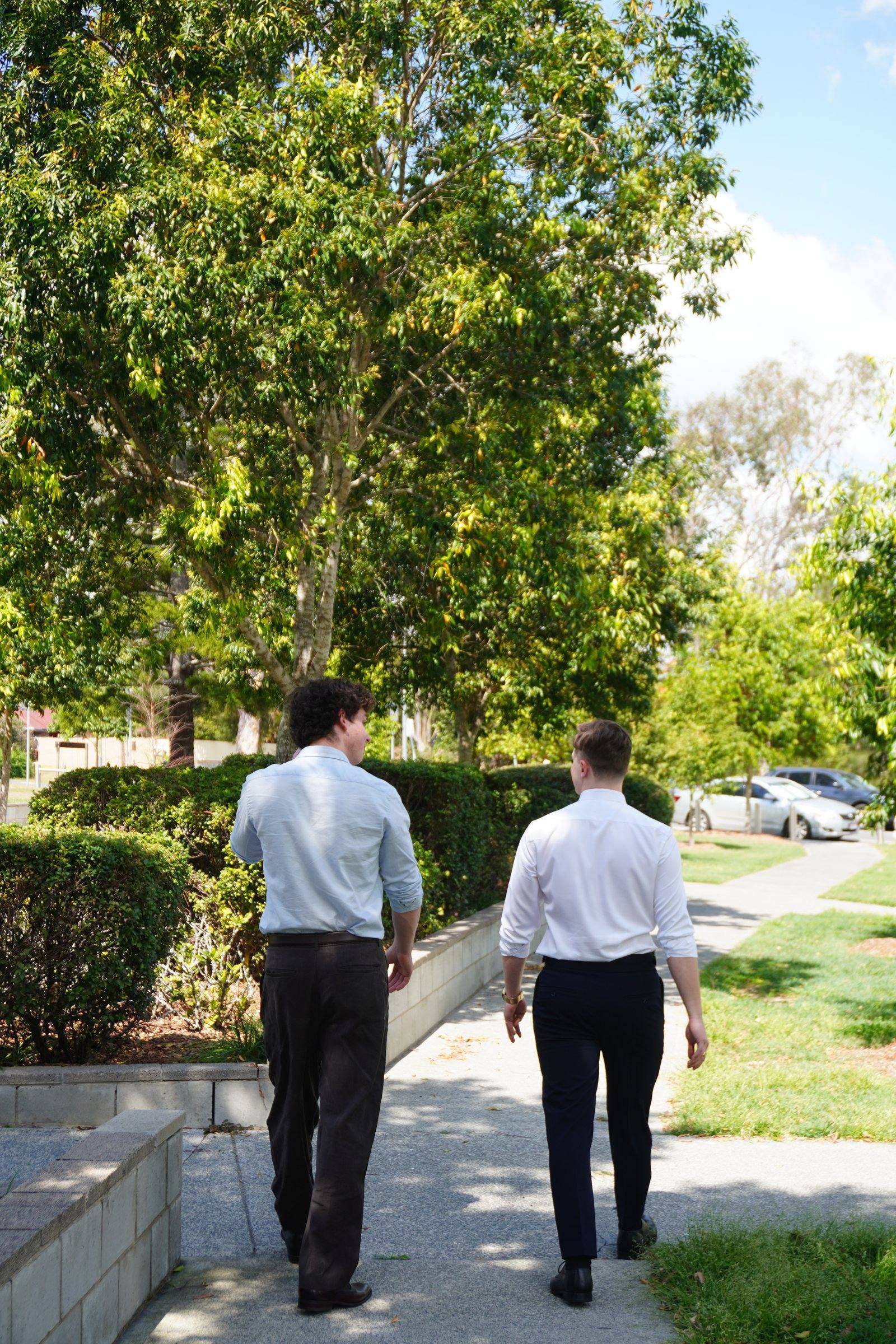 Levi and Zeek walking away along a garden path