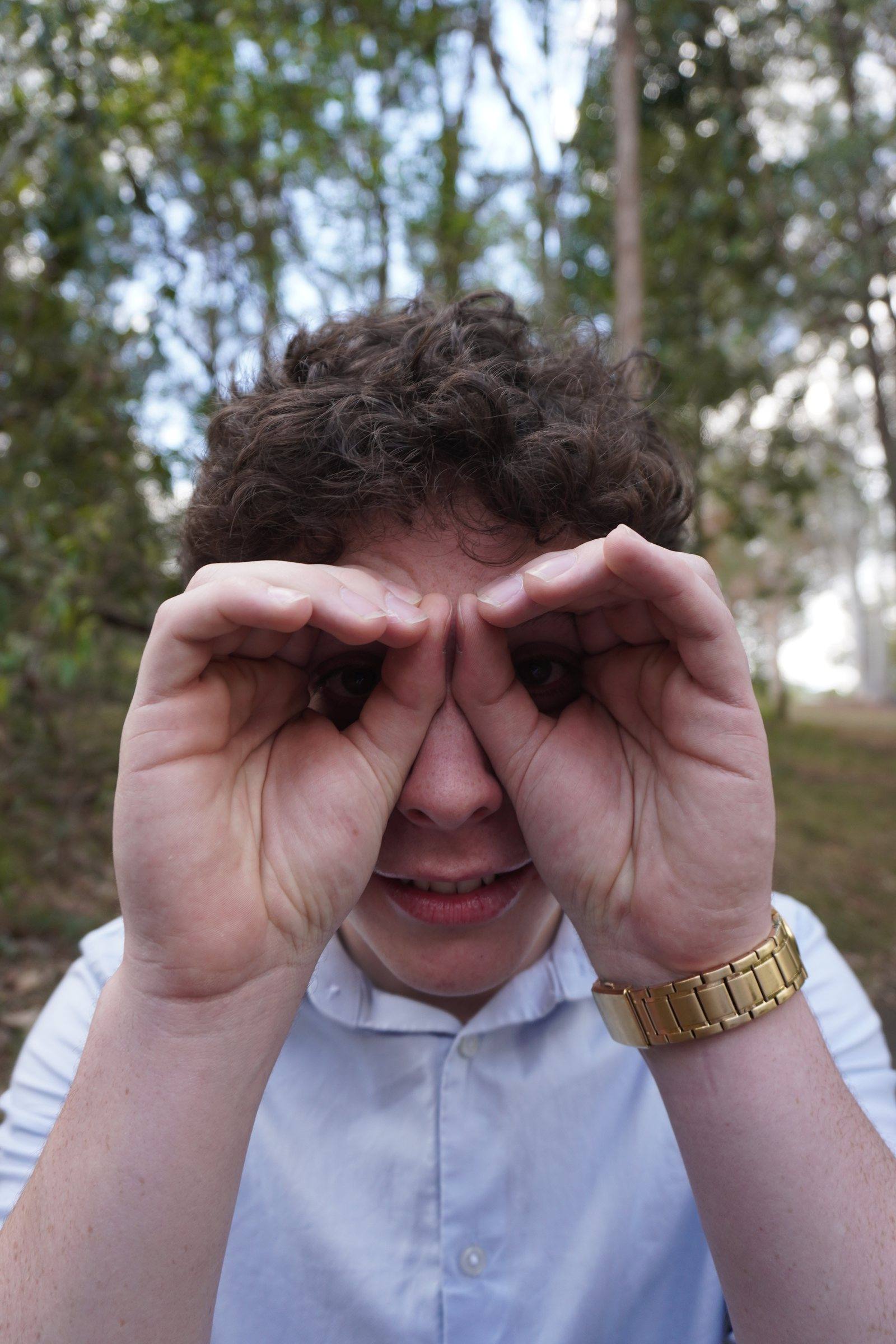 Levi making binoculars with his hands, mid-laugh